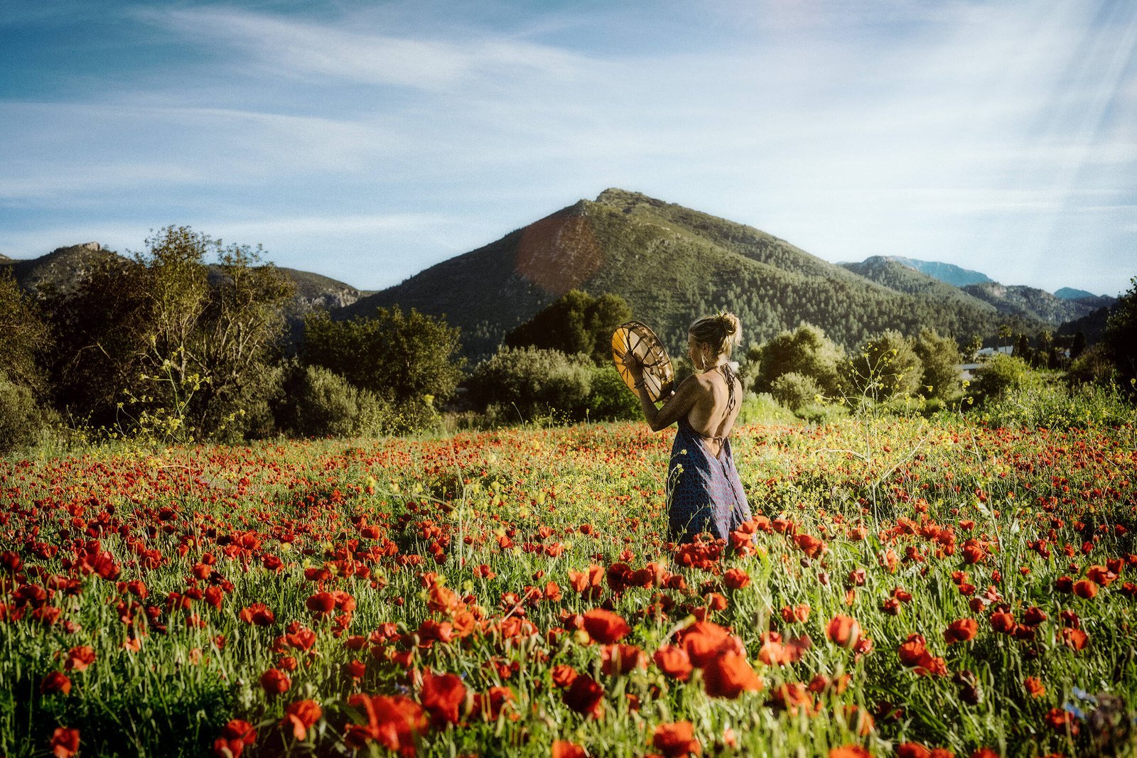 Intuition, Bauchgefühl, weibliche Selbstermächtigung, Frau steht inmitten einem feuerroten Mohnblumenfeld