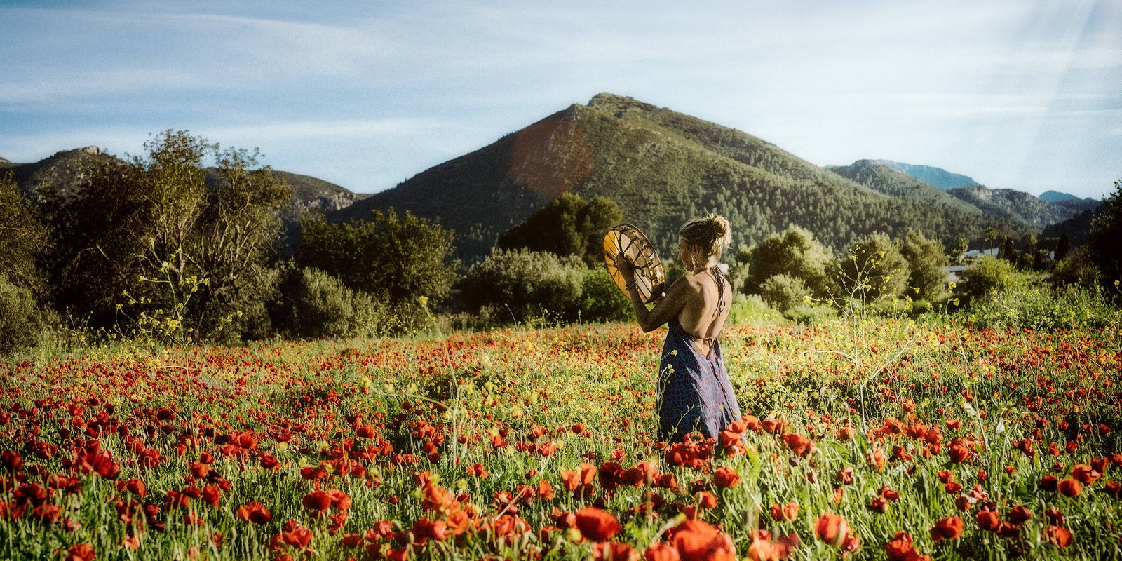 Intuition, Bauchgefühl, weibliche Selbstermächtigung, Frau steht inmitten einem feuerroten Mohnblumenfeld
