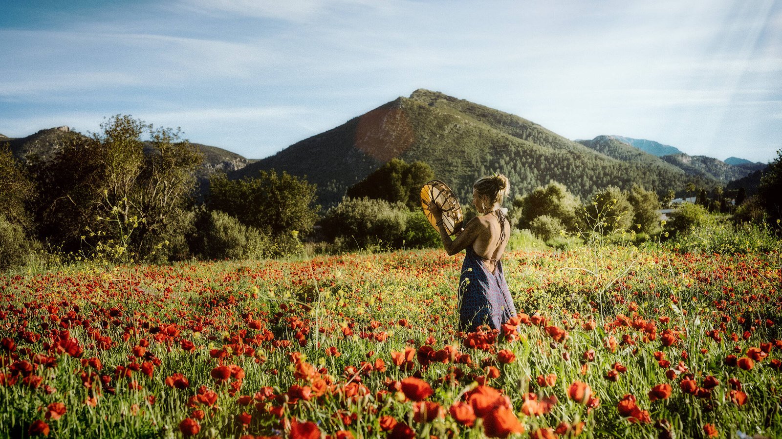 Intuition, Bauchgefühl, weibliche Selbstermächtigung, Frau steht inmitten einem feuerroten Mohnblumenfeld